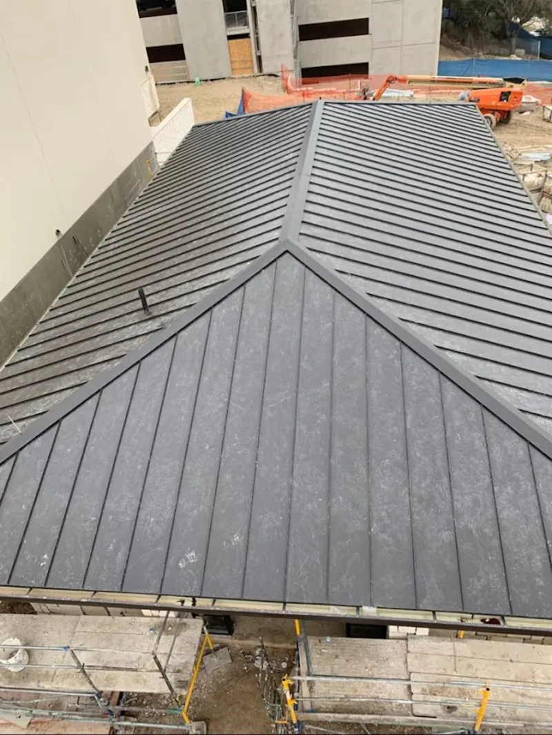Commercial metal roof construction with crane equipment in Weston